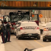 Un camion de pompiers sous un pont encerclé de voitures de police.