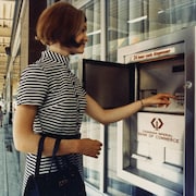 Une femme en train de retirer de l'argent à un des premiers guichets automatiques à Toronto.