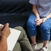 Une femme discute avec une psychologue dans le cadre d'une séance de psychothérapie.