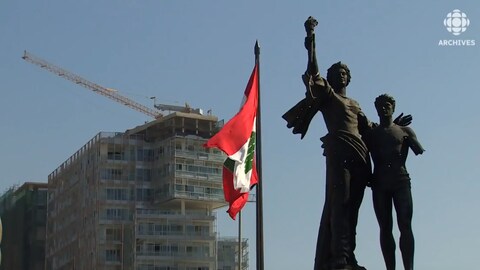 À Beyrouth, le drapeau libanais flotte devant un immeuble en construction.  