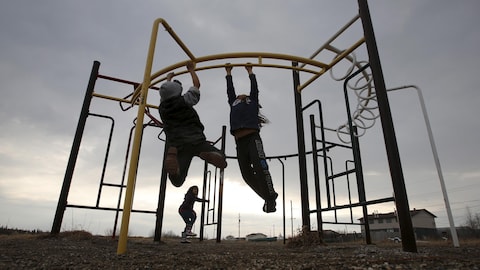 Des enfants jouent dans un parc situé dans la communauté d'Attawapiskat, dans le nord de l'Ontario.