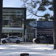 Une voiture de police devant un bâtiment avec l'inscription «Centre d'hébergement Roland-Leclerc».