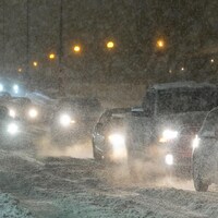 Des voitures à la queue leu-leu sous la neige.