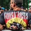 Un homme posé avec un t-shirt de Guns and roses. 