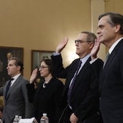 Les quatre témoins sont debout, la main droite levée pour prêter serment. 