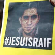 Une pancarte avec la photo de Raif Badawi et la mention « Je suis Raif ». 