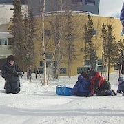 Des écoliers en hiver glissent dans la cour de l'école Allain St-Cyr.