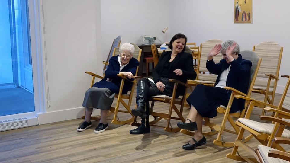 Soeur Louise-Hélène Albert, la directrice du Musée des Ursulines Josée Grandmont et soeur Yvette Isabelle rient ensemble, alors qu'elles sot assises dans les chaises berçantes. 