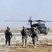 Des soldats devant un hélicoptère