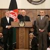 Ashraf Ghani se tient debout derrière un lutrin, avec le bras droit qui pointe vers le haut.