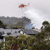 Un hélicoptère arrose des maisons.