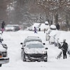 Une rue de Montréal et des voitures ensevelies sous la neige.