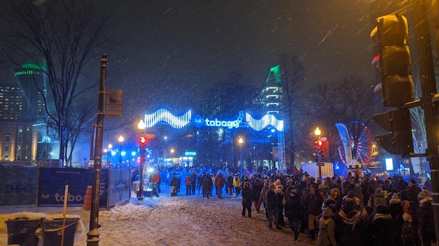 Une foule dans la rue avec des lumières et des flocons de neige