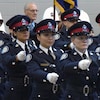 Des femmes et des hommes en uniforme de la police de Toronto, en rang, lors d'une cérémonie.