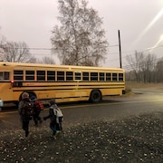 cinq élèves traversent la rue pour se rendre à l'autobus.