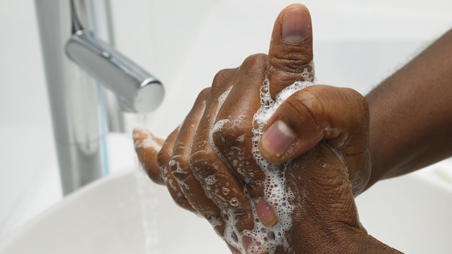 Une personne se lavent les mains.