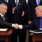 Le vice-premier ministre chinois Liu He et le président des États-Unis Donald Trump se serrent la main.