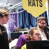 Les trois cofondateurs de Chasing Rats games regardent un ordinateur d'écran.
