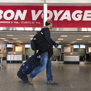 Un voyageur marche dans un couloir de l'aéroport Montréal-Trudeau.
