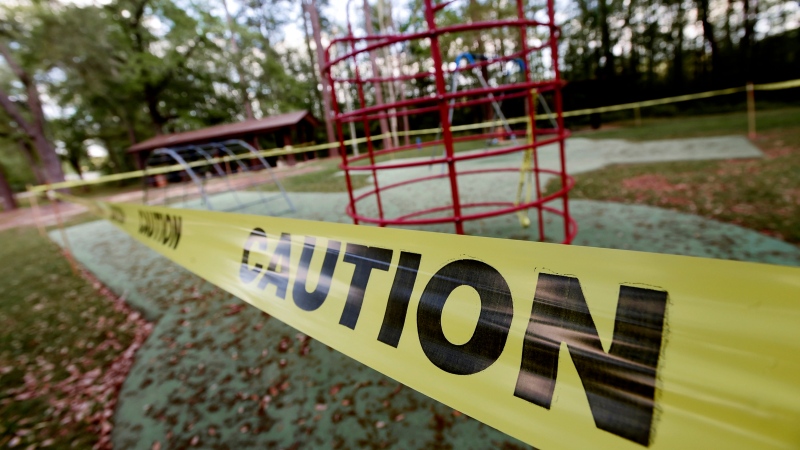 In this Thursday, March 26, 2020, photo, playground equipment is surrounded by caution tape at Wayside Park in Crestview, Fla. Beaches and many public parks and spaces have been closed recently in an attempt to stop the spread of the new coronavirus. (Devon Ravine/Northwest Florida Daily News via AP)