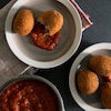 Des boules frites dans des bols avec une sauce tomatée espagnole.