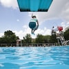 Une fillette saute d'un plongeon dans une piscine publique.