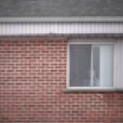 Une personne aînée regarde par sa fenêtre de sa résidence.