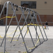 Une banderole entoure les installations pour balançoires dans une cour d'école.