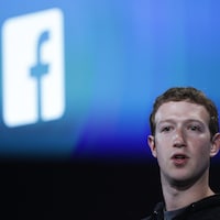 Le fondateur de Facebook, Mark Zuckerberg, devant le logo de Facebook.