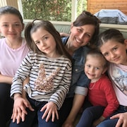 Julie St-Laurent assise sur un divan avec ses quatre filles. 
