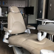 Un fauteuil au milieu du cabinet de consultation d'un dentiste.