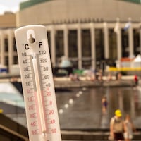 Un thermomètre devant la Place des Arts de Montréal montre une température de 36 degrés celcius.