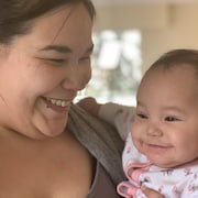 Une mère autochtone tient son bébé et les deux sourient.