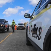 Un policier discute avec un automobiliste à un point de contrôle routier.  