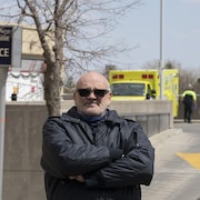 Un homme devant l'Hôpital Notre-Dame de Montréal.