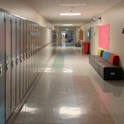Un couloir vide avec des casiers dans une école.