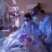 Deux infirmières lors d'une simulation de traitement d'un patient atteint de la COVID-19 à Québec