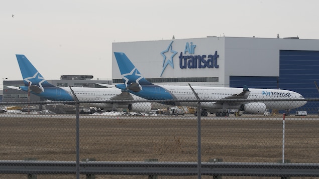 Le bâtiment d'Air Transat et deux avions au sol. 