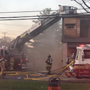 Des pompiers combattent éteignent un incendie survenu dans un restaurant. 