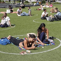 Deux femmes dans un cercle peint au sol dans un parc.