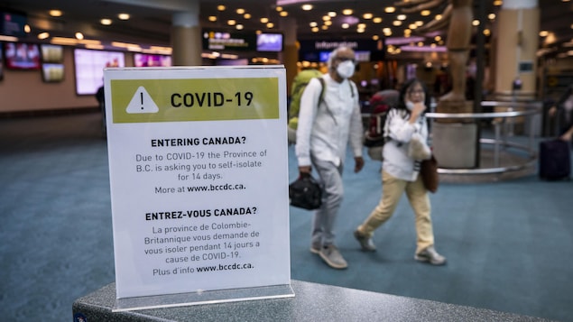 Une affiche sur le coronavirus a l'aéroport de Vancouver.