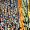 Des rangs de petites perles multicolores sur un étalage.