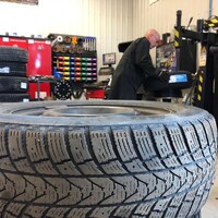Un garagiste travaille sur des pneus.