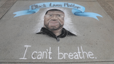 Un dessin de George Floyd à la craie sur le trottoir avec un bandeau Black Lives Matter et le slogan "I can't breathe".