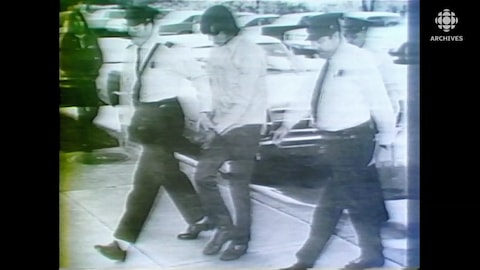 Donald Marshall, menotté, escorté par des policiers.