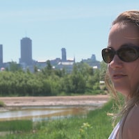 Une jeune femme avec, en arrière-plan, la silhouette de la Ville de Québec