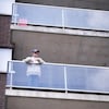 Un homme âgé sur son balcon.