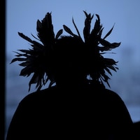 L'ombre d'un autochtone portant une coiffure traditionnelle est photographié lors d’une conférence de presse concernant la décision de la Cour d’appel fédérale de rejeter un appel de plusieurs Premières Nations contre l’expansion du pipeline Trans Moutain à Vancouver, en Colombie-Britannique, le mardi 4 février 2020.