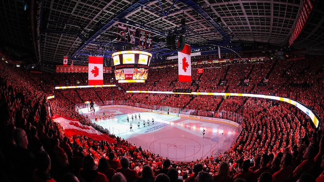 Photo du domicile des Flames de Calgary bondé de spectateurs, avec un drapeau canadien à l'écran géant. 