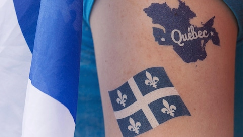Une femme arbore des tatouages de la carte et du drapeau du Québec, dans le cadre des festivités de la fête nationale du Québec.